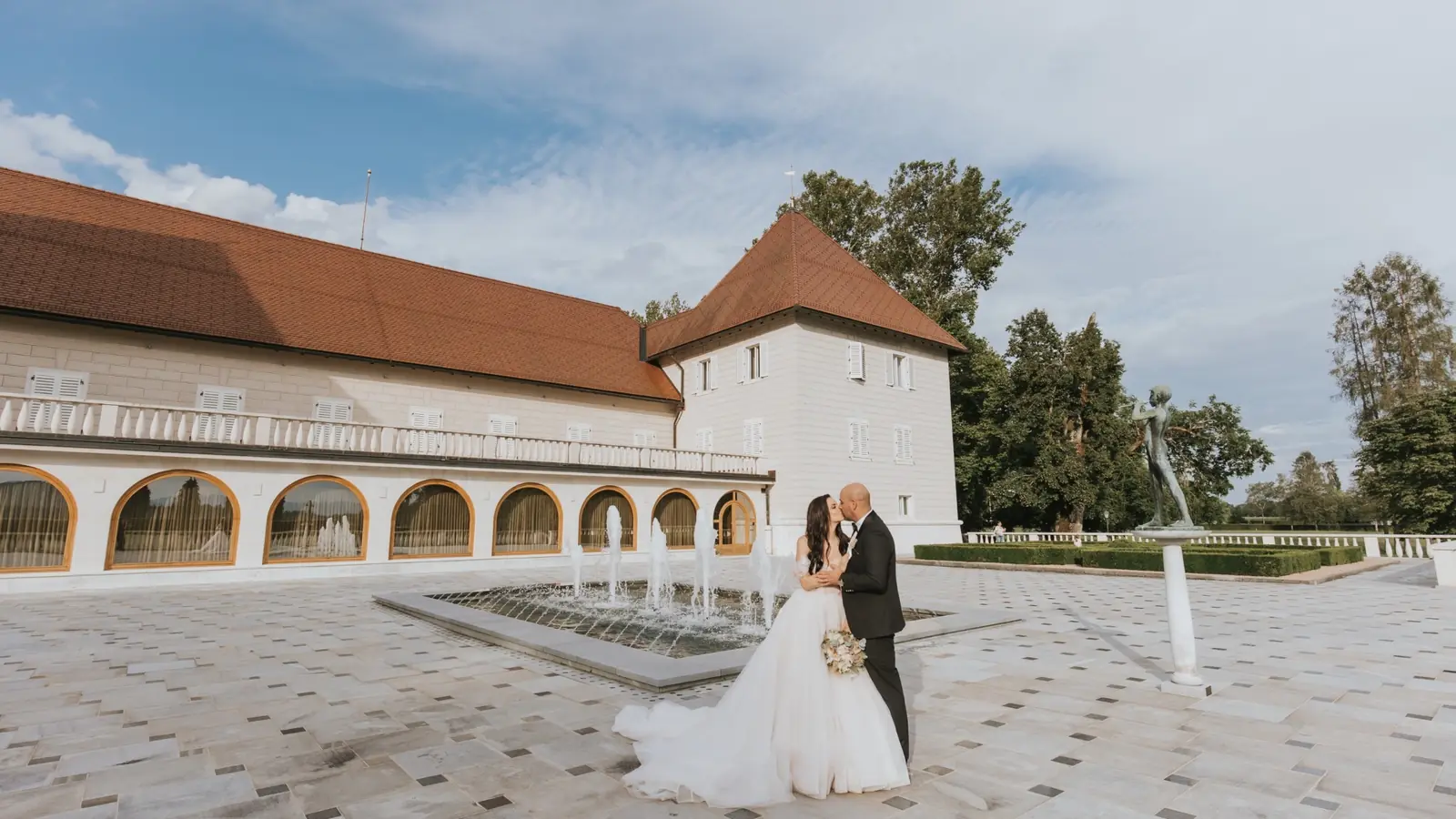 Mladoporočenca pred poročnim prizoriščem – deljenje poročnih fotografij brez aplikacije